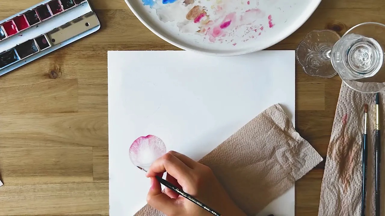 Overhead view of Daria painting a botanical study from a live session