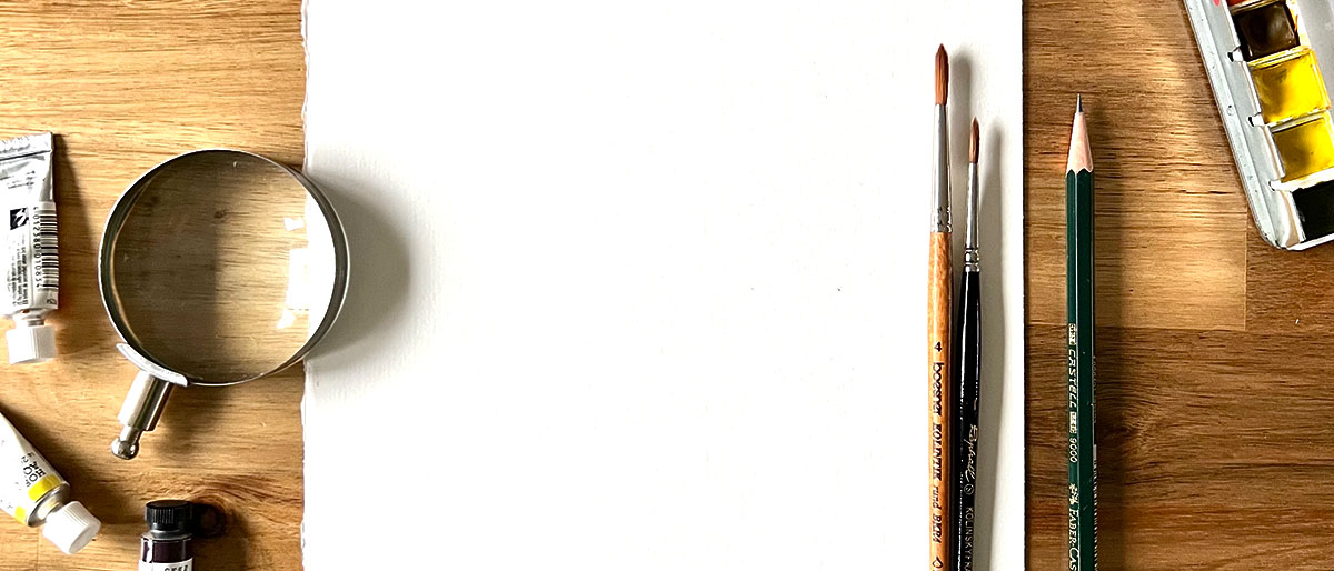Blank archival paper with watercolour brushes, pigments, and magnifying glass — ready for your commission